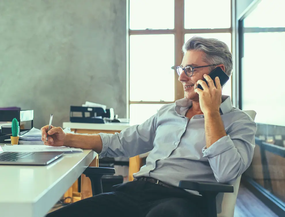 Hombre al teléfono en su escritorio