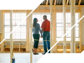 A couple stands in a house under construction and looks at each other.