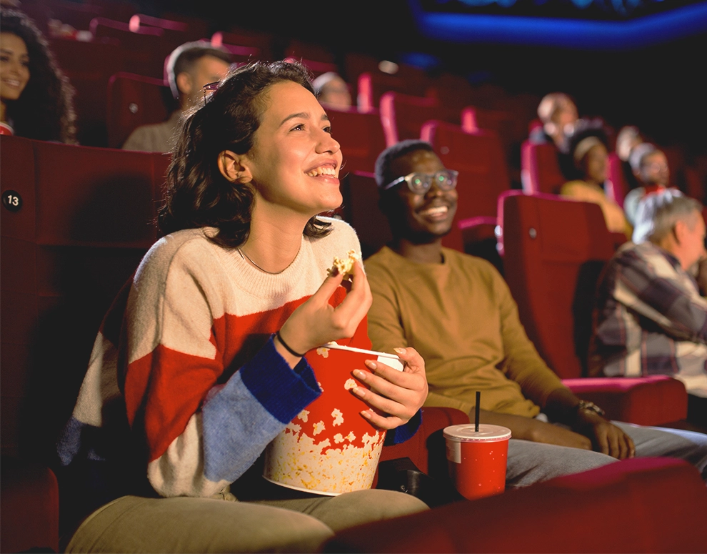 A woman watching a movie in the theater.
