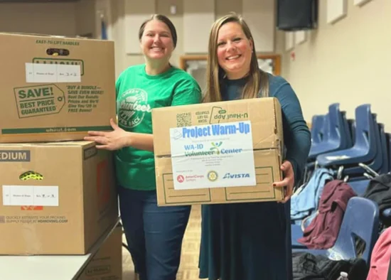 ICCU Volunteers holding donation boxes for Project Warm-Up at a community collection event