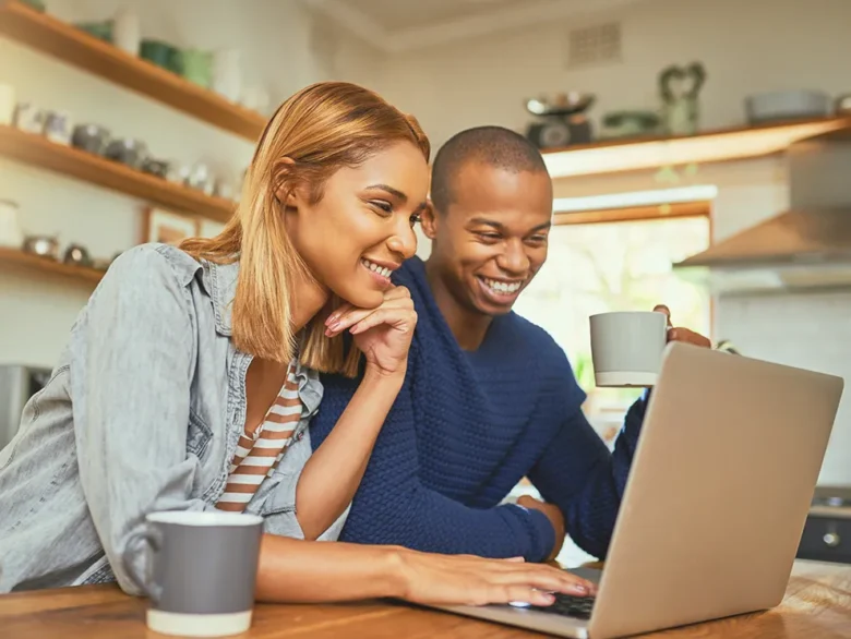 Couple reviewing information together on a laptop at home, representing online banking support and digital financial assistance
