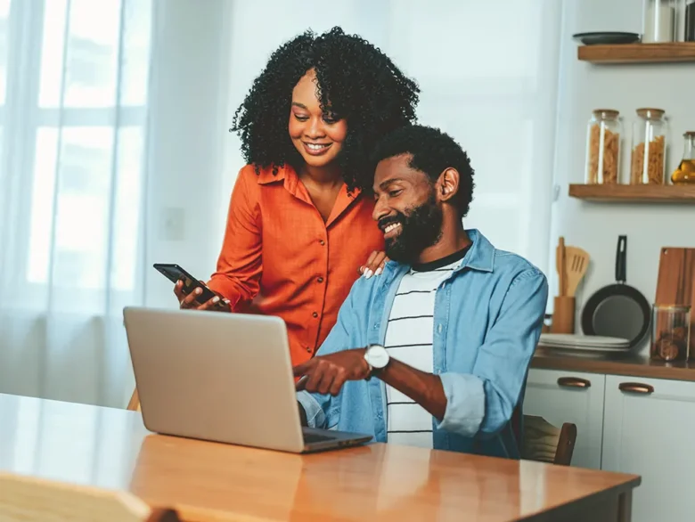 Individuals reviewing account information on a laptop and smartphone, symbolizing secure eBranch sign in and account access