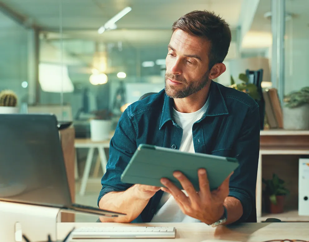 Individual using a tablet at a desk, symbolizing secure eBranch sign in and account management