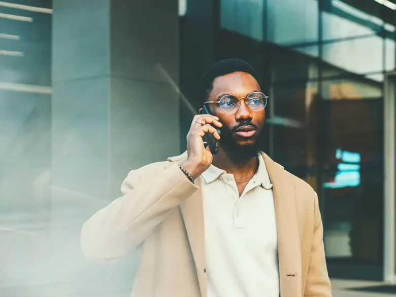 Person speaking on a smartphone outside a modern office building