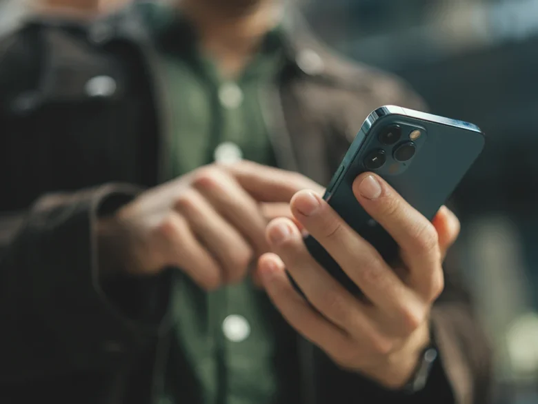 Person in green checking their phone for account login help