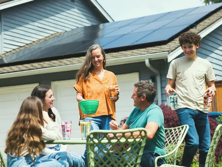 Residential home with rooftop solar panels during an outdoor gathering, representing solar loan benefits and energy savings