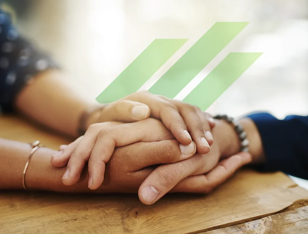 Two people holding hands in support of wildfire-affected communities.