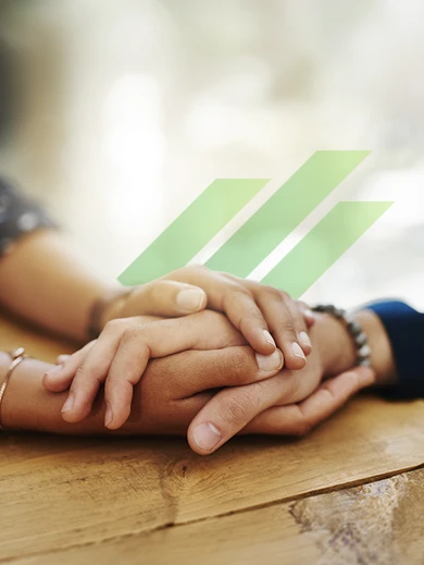 Two people holding hands as a symbol of support, connection, and community during challenging times.